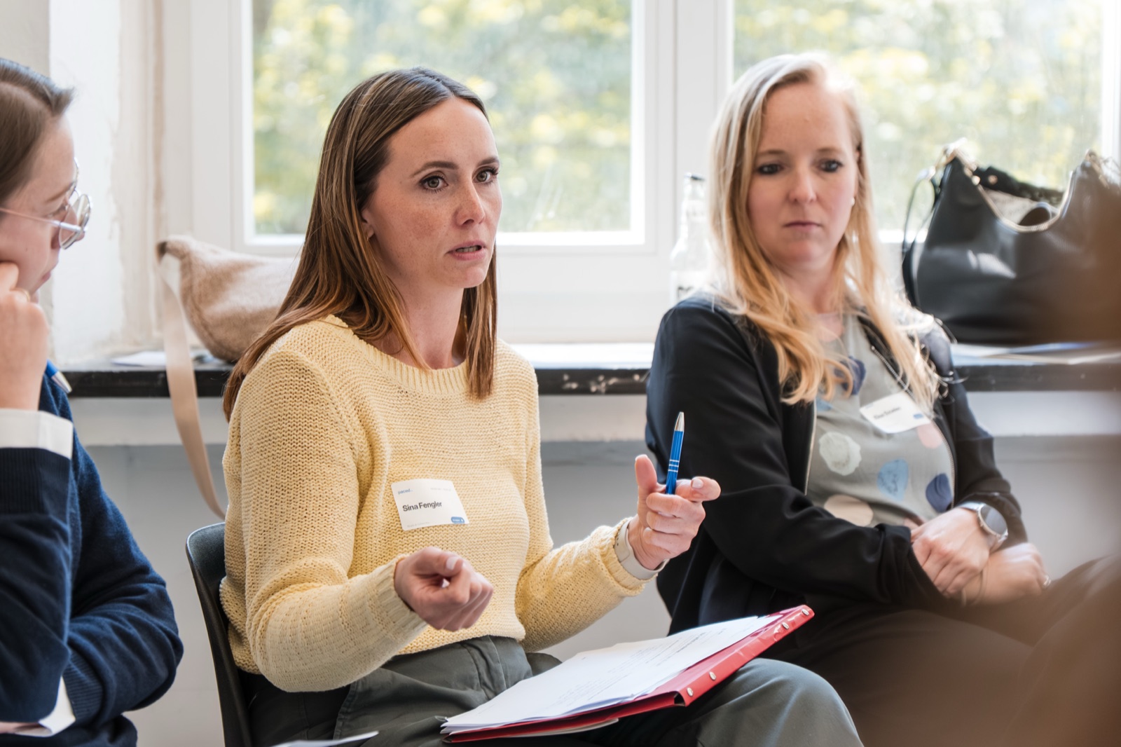 Eine Teilnehmerin diskutiert gestikulierend mit zwei anderen Frauen beim PACED Day